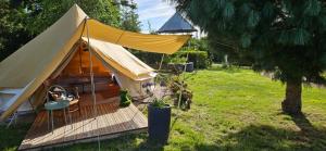 a large tent in a yard with a tree at Lodge18 in Châteaumeillant