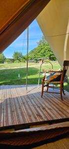 a porch with a bench on a wooden deck at Lodge18 in Châteaumeillant