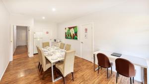 a dining room with a white table and chairs at The Cottage Motor Inn Albury CBD in Albury