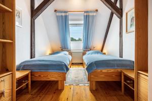 two beds in a room with a window at Schwalbennest in Trebel