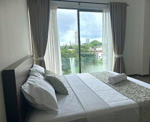 a bedroom with a bed with a large window at Water Park Suites in Nugegoda +23 photos