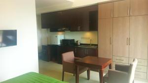 a kitchen with a table and chairs and cabinets at Water Park Suites in Nugegoda