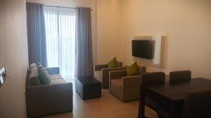 a living room with two couches and a tv at Water Park Suites in Nugegoda