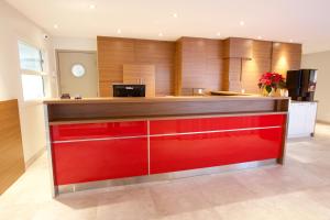 a kitchen with red cabinets and a red counter top at Hôtel Motel Le Voyageur in Saint-Georges