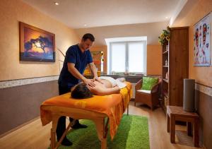 a man standing next to a woman laying on a bed at Garden Depandance Am Bach in Kurort Altenberg