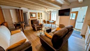a living room with couches and a dining room with a table at Villetelle in Cheissoux