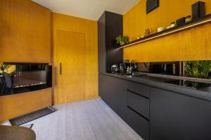 a kitchen with yellow and black cabinets and a counter at Kutica in Nová Baňa