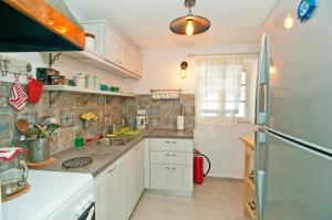 a kitchen with a sink and a refrigerator at Captain Mike's Villa II in Syvota