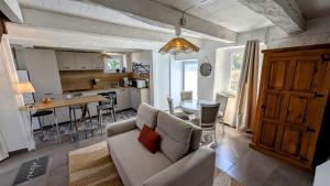 a living room with a couch and a kitchen at Petit villetelle in Cheissoux