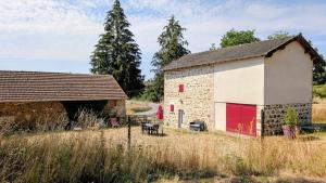 an old barn with red doors in a field at Petit villetelle in Cheissoux +4 photos