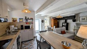 a kitchen and living room with a table and a couch at Petit villetelle in Cheissoux