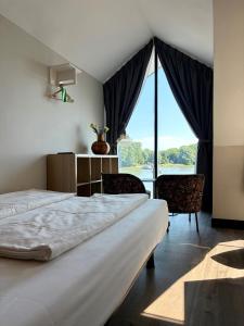 a bedroom with two beds and a large window at Hotel Oostereiland in Hoorn +68 photos