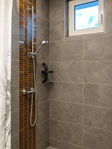 a bathroom with a shower with a window at A Napos Oldal Vendégház in Abaújkér +21 photos