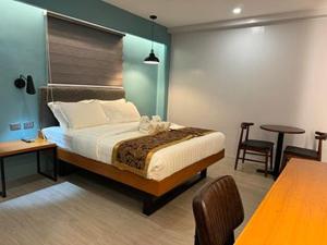 a bedroom with a bed and a table and chairs at ECL Travellers Inn in Nabas