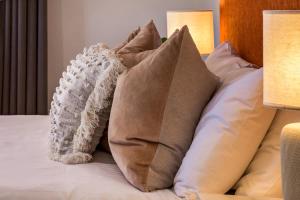 a pile of pillows on a bed with two lamps at Lana Unit 31 Studio Apartment - Central Base for South West Adventures in Margaret River Town