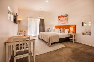 a bedroom with a large bed and a table and a desk at Lana Unit 31 Studio Apartment - Central Base for South West Adventures in Margaret River Town +13 photos