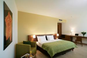 a hotel room with a bed and a chair at Hotel Die Zeit in Sankt Veit an der Glan