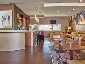 a lobby of a hotel with tables and a bar at Hotel Die Zeit in Sankt Veit an der Glan