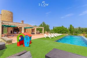 a house with a swimming pool with a play house at Villa Son Bennasar by Slow Villas in Felanitx