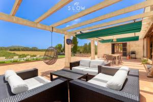 a patio with couches and a table and chairs at Villa Son Bennasar by Slow Villas in Felanitx