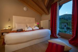 a bedroom with a large bed and a large window at Hotel Cristallo in Livigno +75 photos