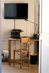 a desk with a television and a wooden chair at One Suite Hotel - Zollhaus in Bern +24 photos
