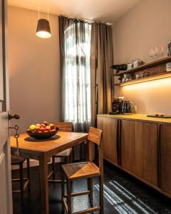a kitchen with a table with a bowl of fruit on it at One Suite Hotel - Zollhaus in Bern