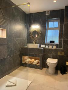 a bathroom with a toilet and a sink and a mirror at The Véro Townhouse Killarney in Killarney