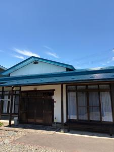 a building with a blue roof and windows at デコピンハウス in Hanamaki