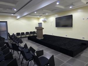 a podium in a room with chairs and a screen at Movela Hotels in Warri +46 photos