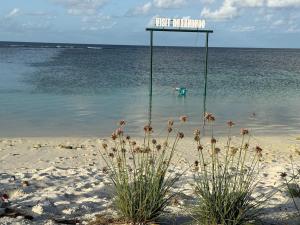 a sign in the water on a beach at Daisy Stay Dhaandhoo in Nilandhoo