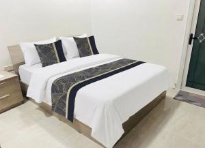a bedroom with a bed with white sheets and pillows at Daisy Stay Dhaandhoo in Nilandhoo