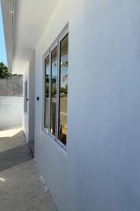 a white building with a window on the side of it at Daisy Stay Dhaandhoo in Nilandhoo