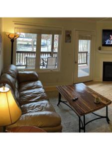 a living room with a leather couch and a coffee table at River & Vine in Helen
