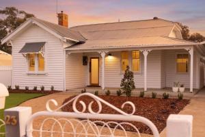 a white house with a white bench in front of it at Yarra Palms in Yarrawonga