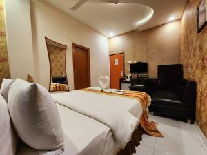 a hotel room with a large bed and a couch at Hotel Housez 43 in Kolkata