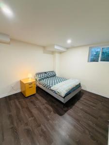 ein Schlafzimmer mit einem Bett und einem gelben Nachttisch in der Unterkunft Niagara Falls 2 Bedrooms 1 and half washroom Luxury Basement Apartment in Thorold