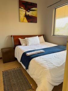 a bedroom with a large bed with a painting on the wall at Premium Getaway @ la Bella Costa in Pretoria