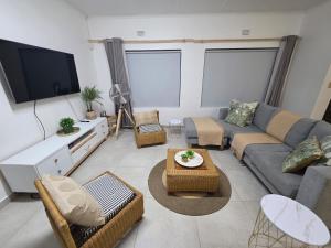 a living room with a couch and a tv at Hello Home Struisbaai in Struisbaai