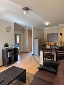 a living room with a couch and a kitchen at Premium Getaway @ la Bella Costa in Pretoria