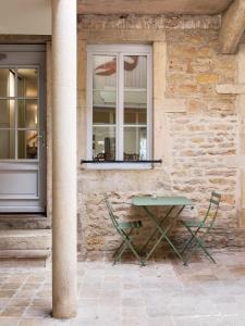 a table and two chairs in front of a building at Alfred Hotels Beaune La Madeleine in Beaune