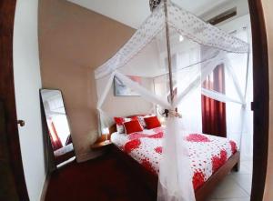 a bedroom with a red and white bed with a canopy at Appartement VIP centre ville in Toamasina
