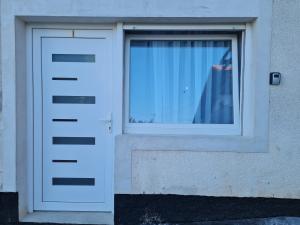 a white door and a window on a building at Apartman Ogulin "Klek Escape" in Sveti Petar
