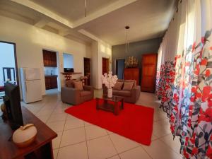 a living room with a couch and a red rug at Appartement VIP centre ville in Toamasina +13 photos