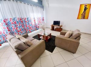 a living room with two couches and a table at Appartement VIP centre ville in Toamasina