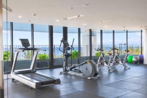 a gym with several exercise bikes in a room with windows at Nesta Celia Danang Hotel in Danang +57 photos