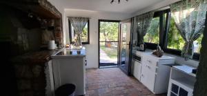 a kitchen with white counters and windows and a door at Filich Home Experience in Labin