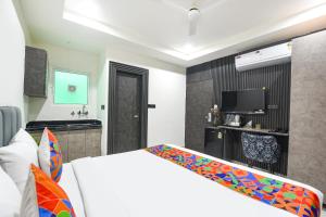 a bedroom with a white bed and a television at FabHotel The Silken Stay in Gurgaon