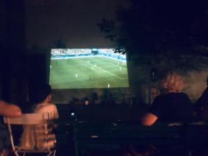 a group of people watching a soccer game on a television at Wild Caspian coast in Aşağıoba