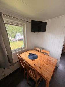 a dining room table with chairs and a window at Saltstraumen camping in Bodø